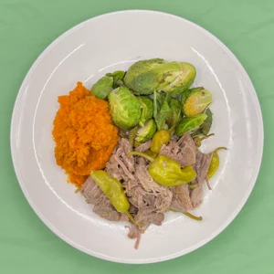 pot roast on a plate with mashed sweet potatoes and brussle sprouts