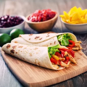 chicken fajita wrap on a cutting board with beans